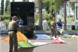 Petugas satpol pp saat membereskan spanduk yang berhasil ditertibkan.